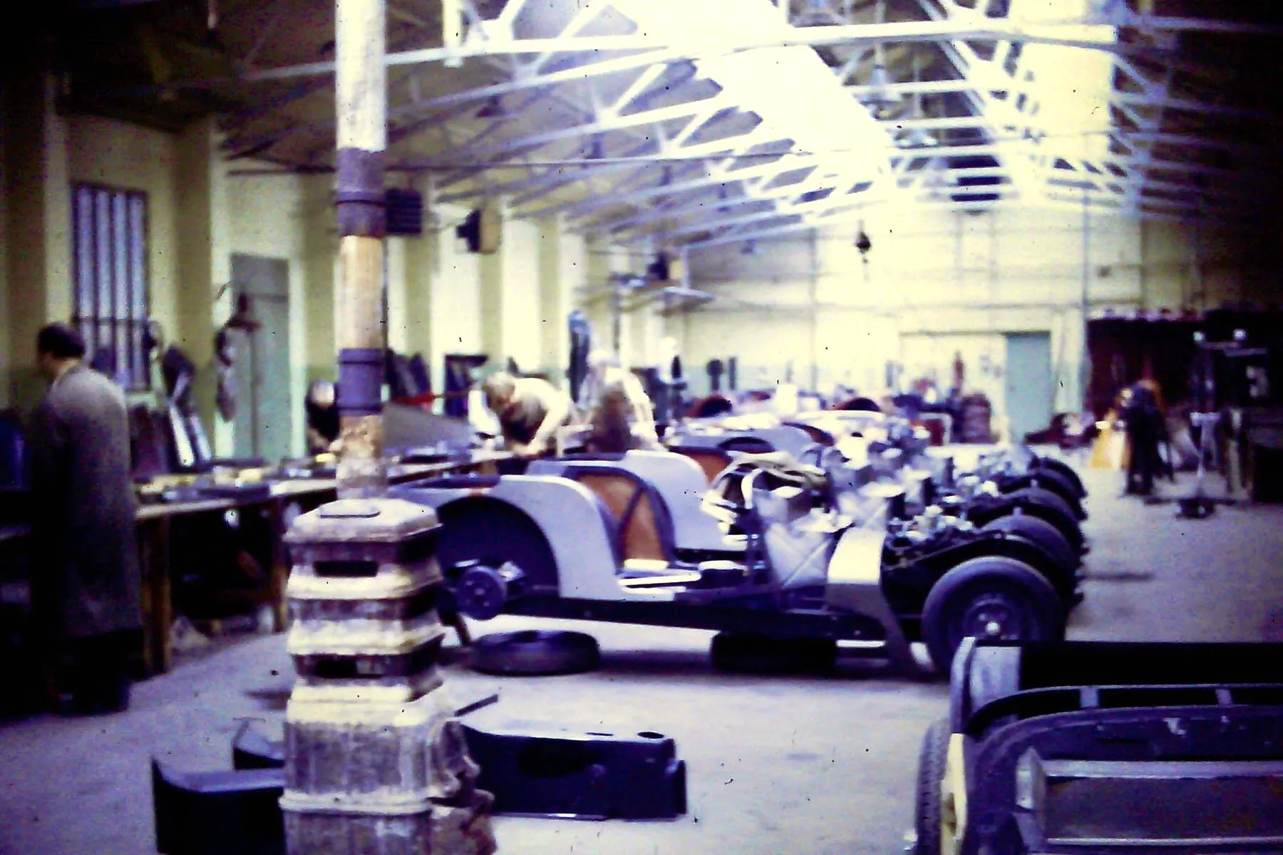 Partly assembled Morgans on the factory floor, with a tall heater among them