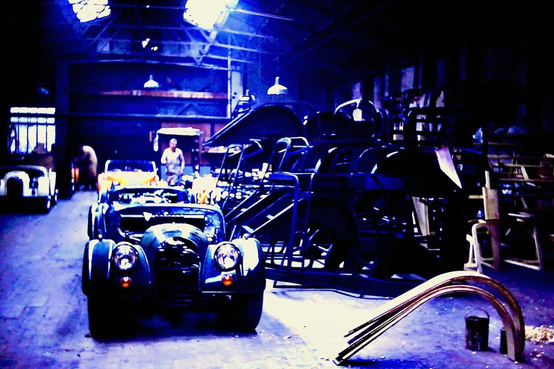 Workers among partly assembled Morgan bodies in the wood-framing shop