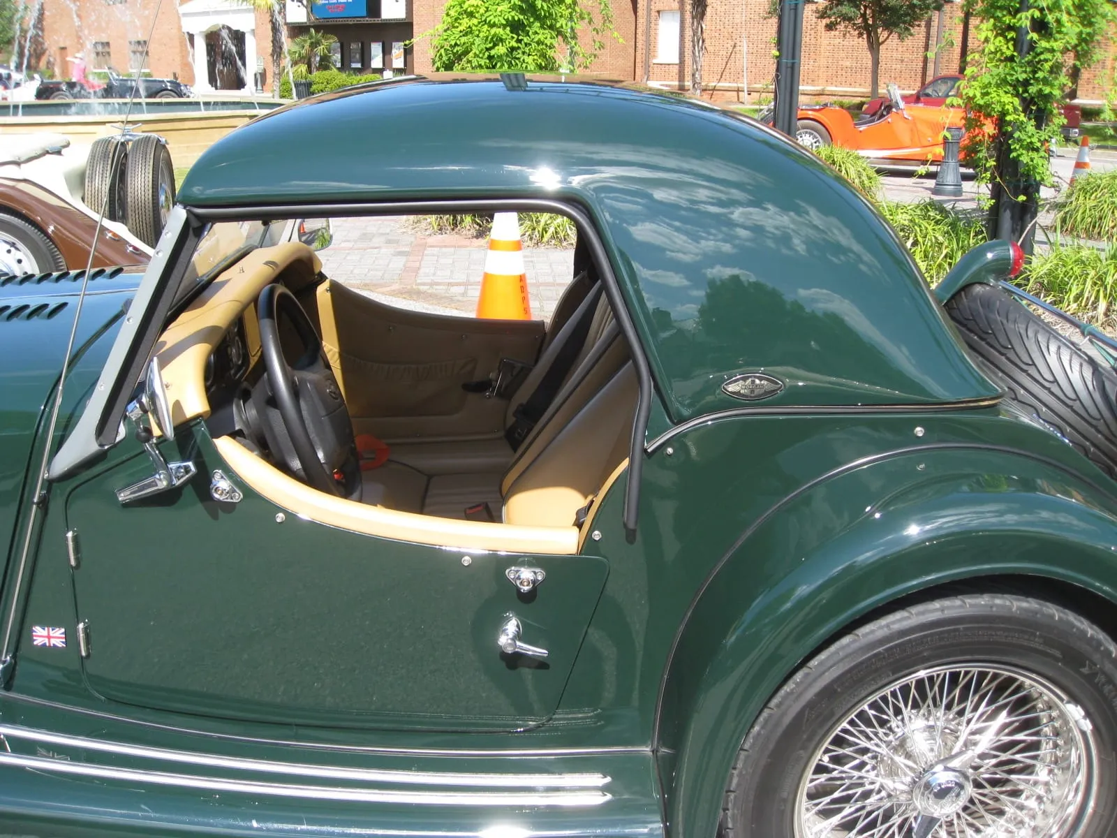 A dark-green 2010 Morgan Roadster with a hardtop, seen through its open door