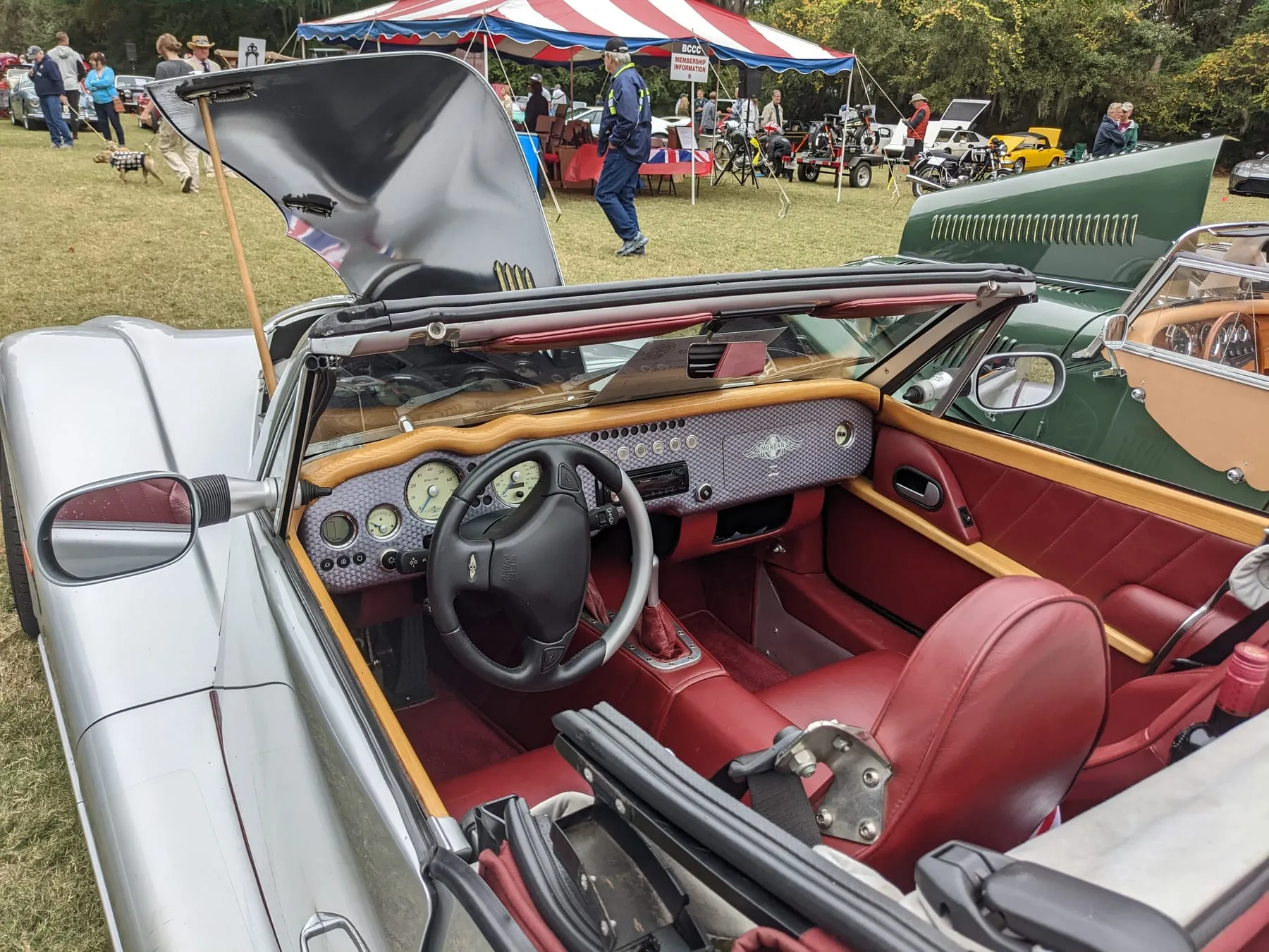 The red leather and wood interior of a silver 2005 Aero 8 Series II, seen from above with its hood down