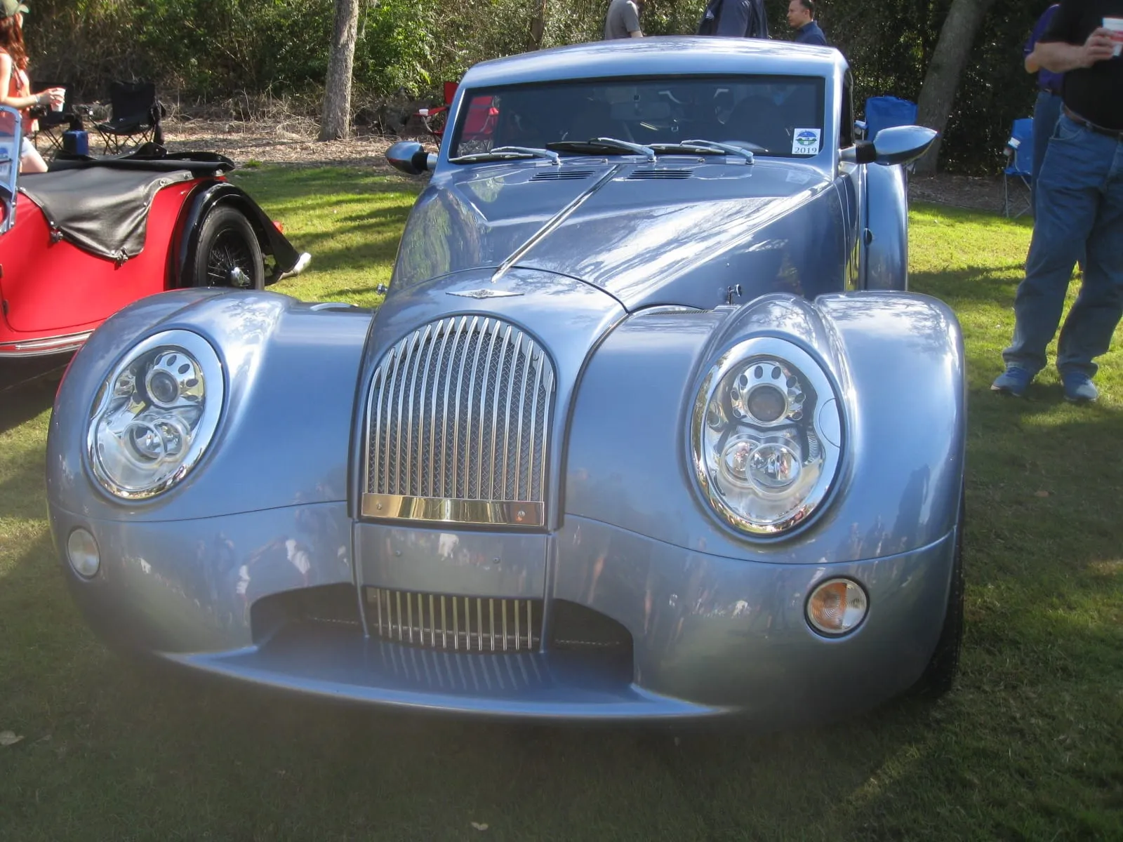 The front of a pale blue Aero Coupé, with headlamps set in the wings, on a lawn
