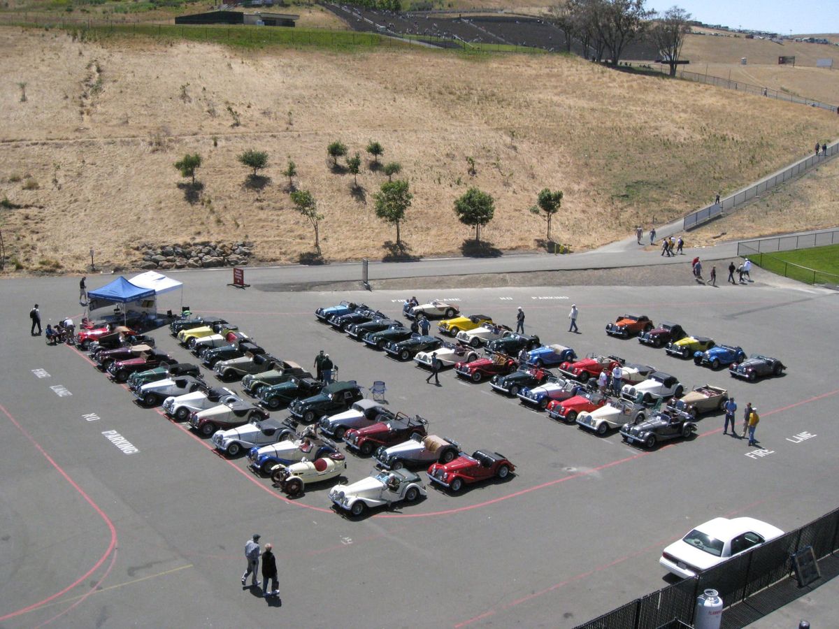 Fifty Morgans parked in rows on a paddock at Sonoma, seen from above