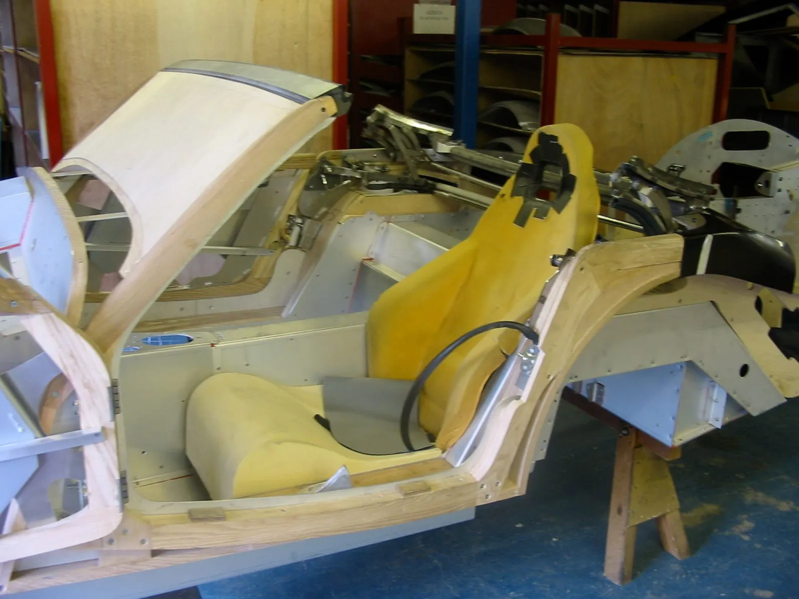 A yellow seat being fitted into a body with its panels open