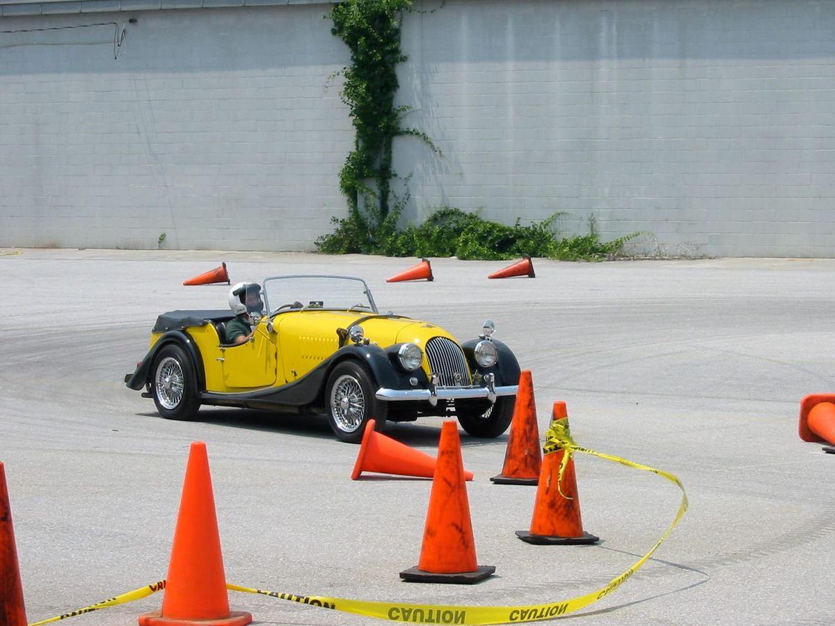 The yellow and black Morgan on a course of orange traffic cones