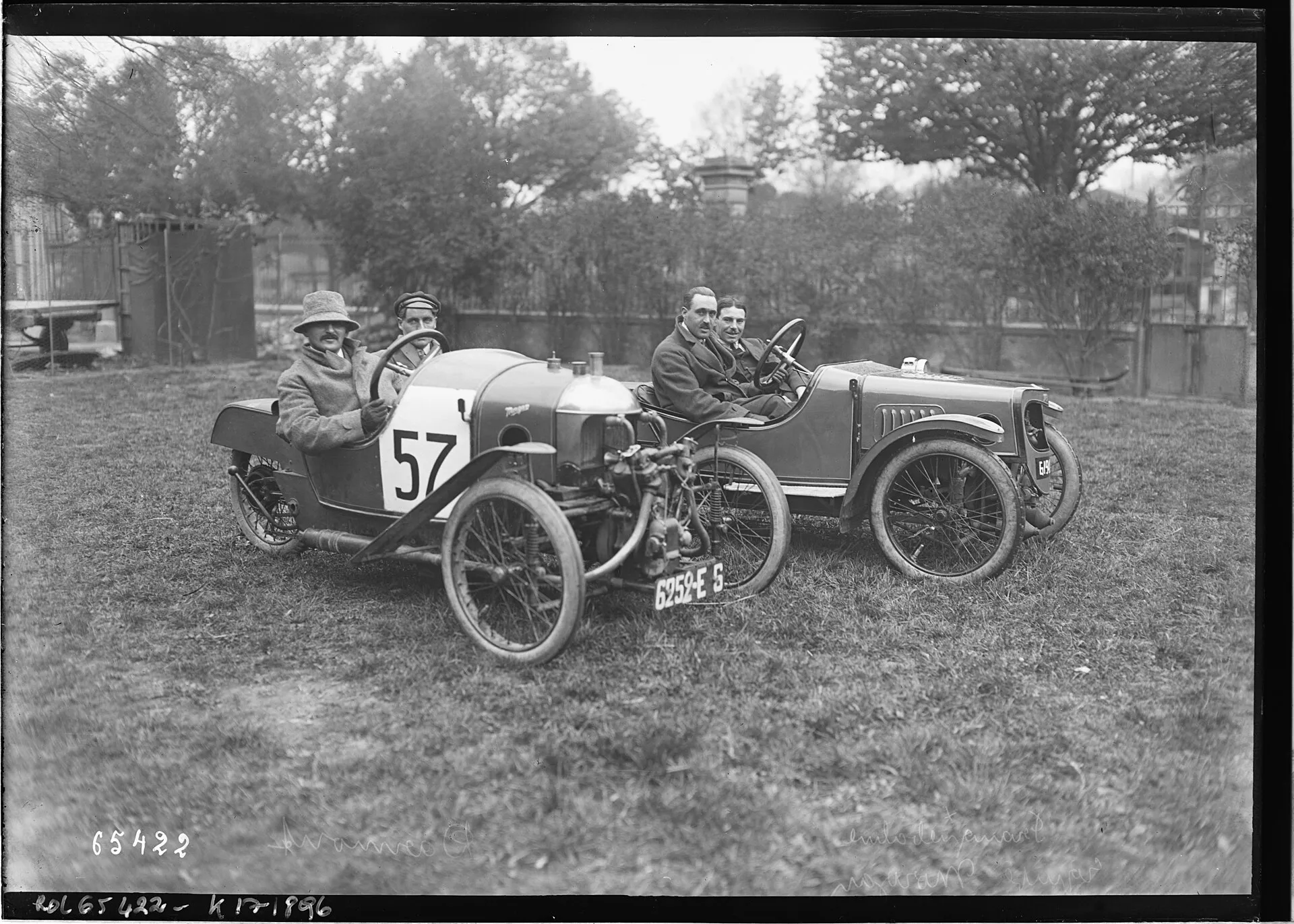 A black-and-white press photograph of André Darmont and Franquebalme standing beside Morgan cyclecars in 1921
