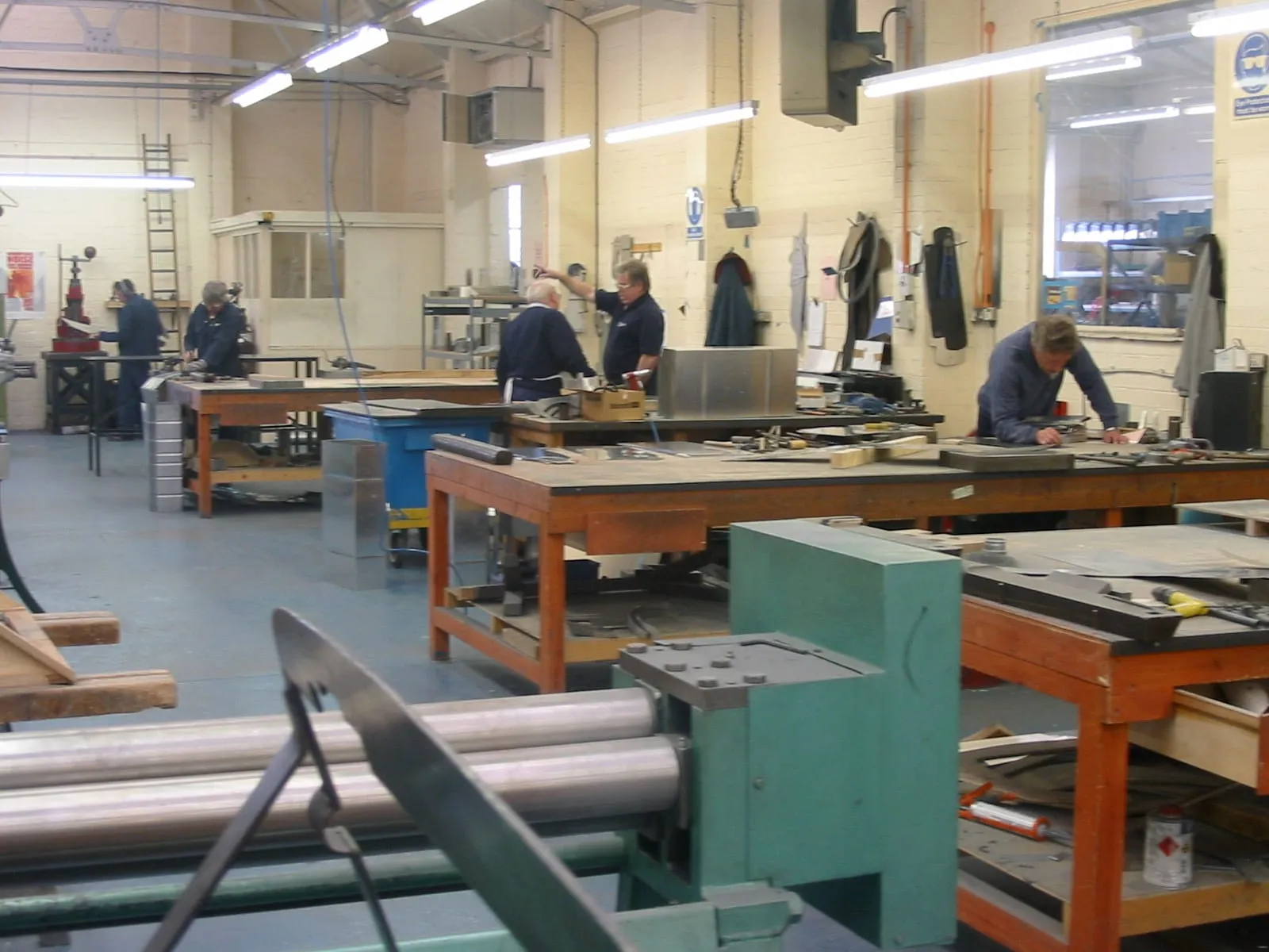 The sheet metal shop, with rolling machines in the foreground and men at benches behind
