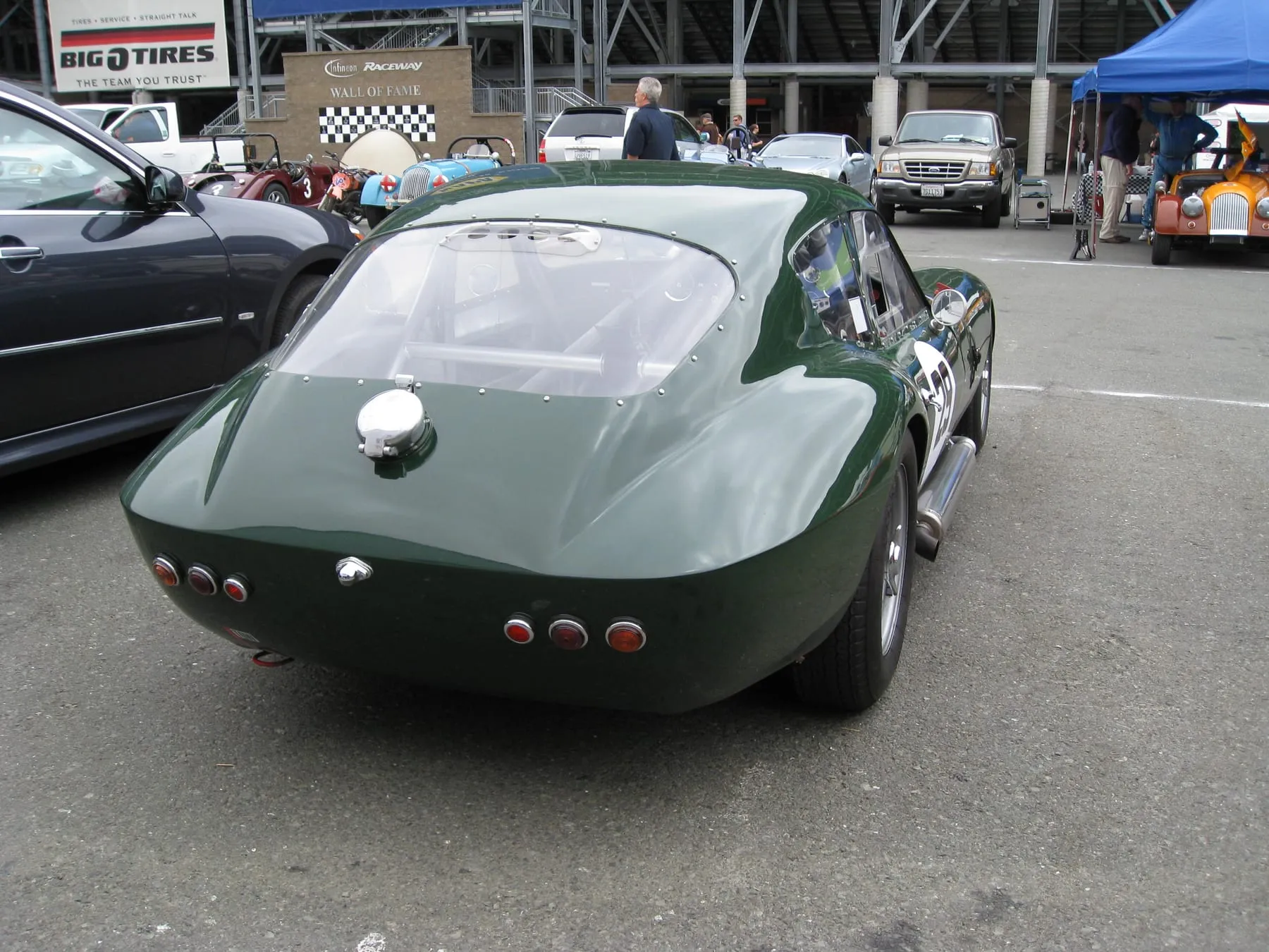 The same dark-green SLR from behind, with its round tail lamps