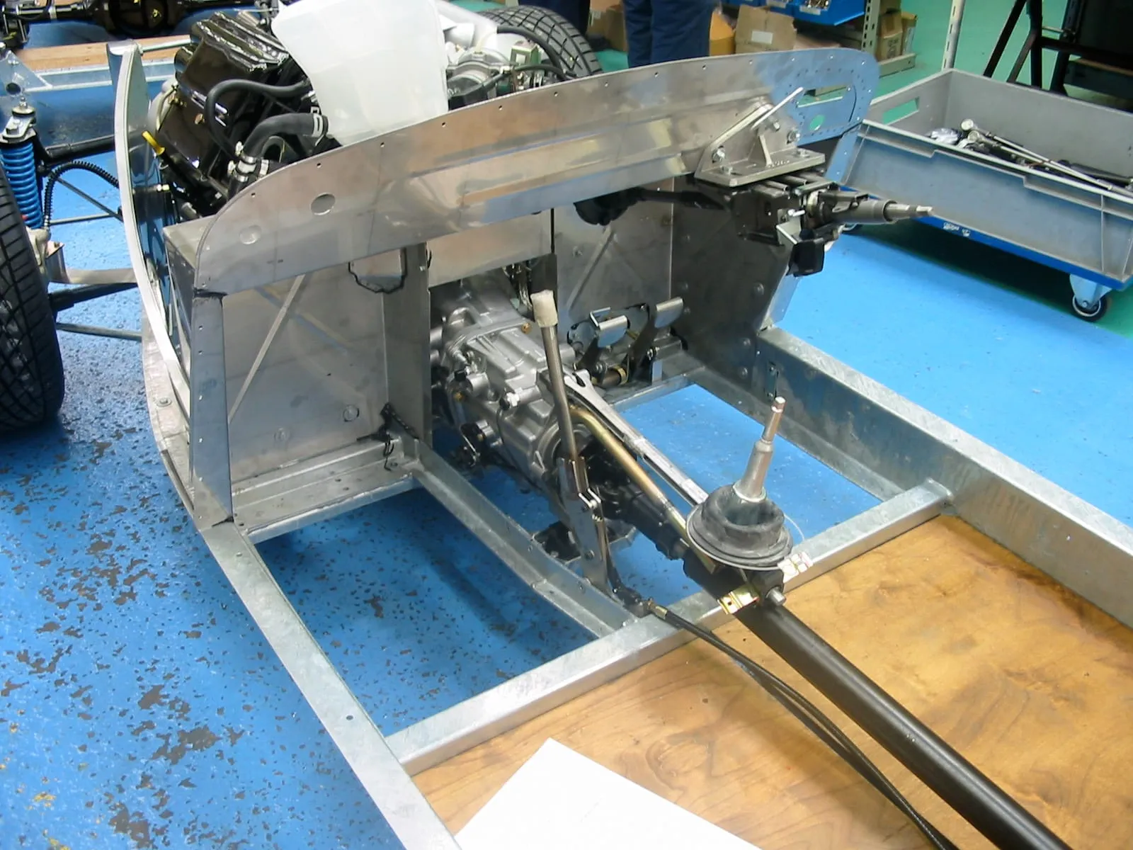 The rear of a galvanised chassis with a gearbox and gear lever, for a V6 Roadster